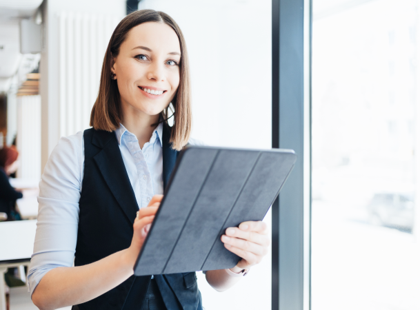 Femme souriante sur une tablette en entreprise